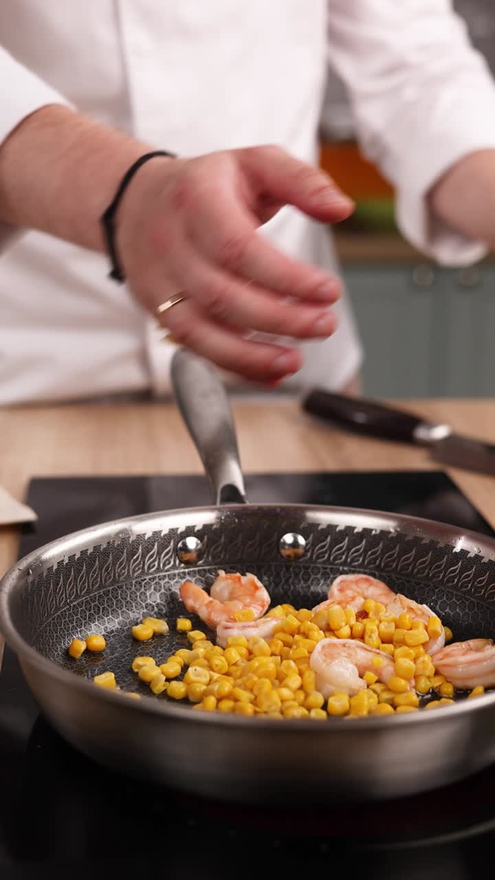 chef cocinando camarones y maíz