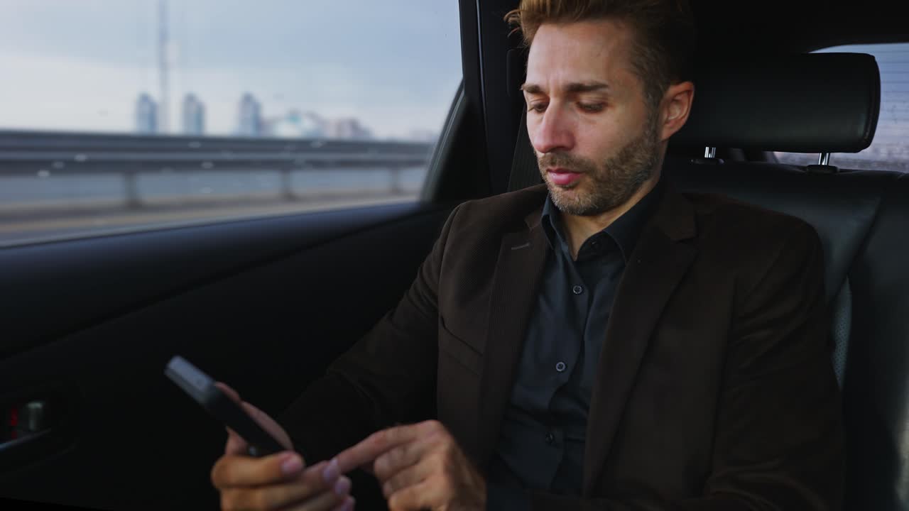 hombre de negocios usando un teléfono inteligente en un coche
