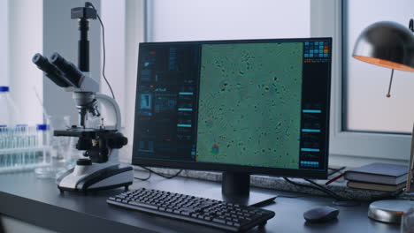 microscopio de laboratorio y computadora con imagen digital