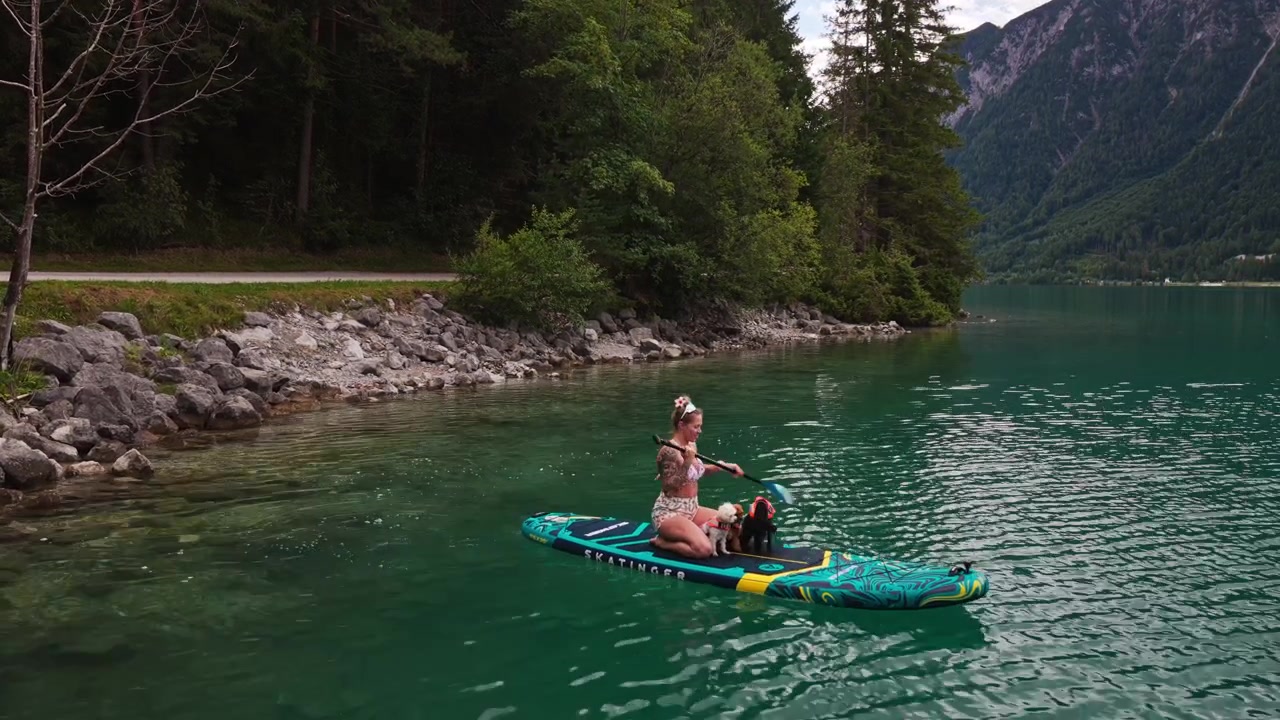 Una donna fa paddleboard con cani sul lago Achensee in Tirolo, Austria - ripresa con drone