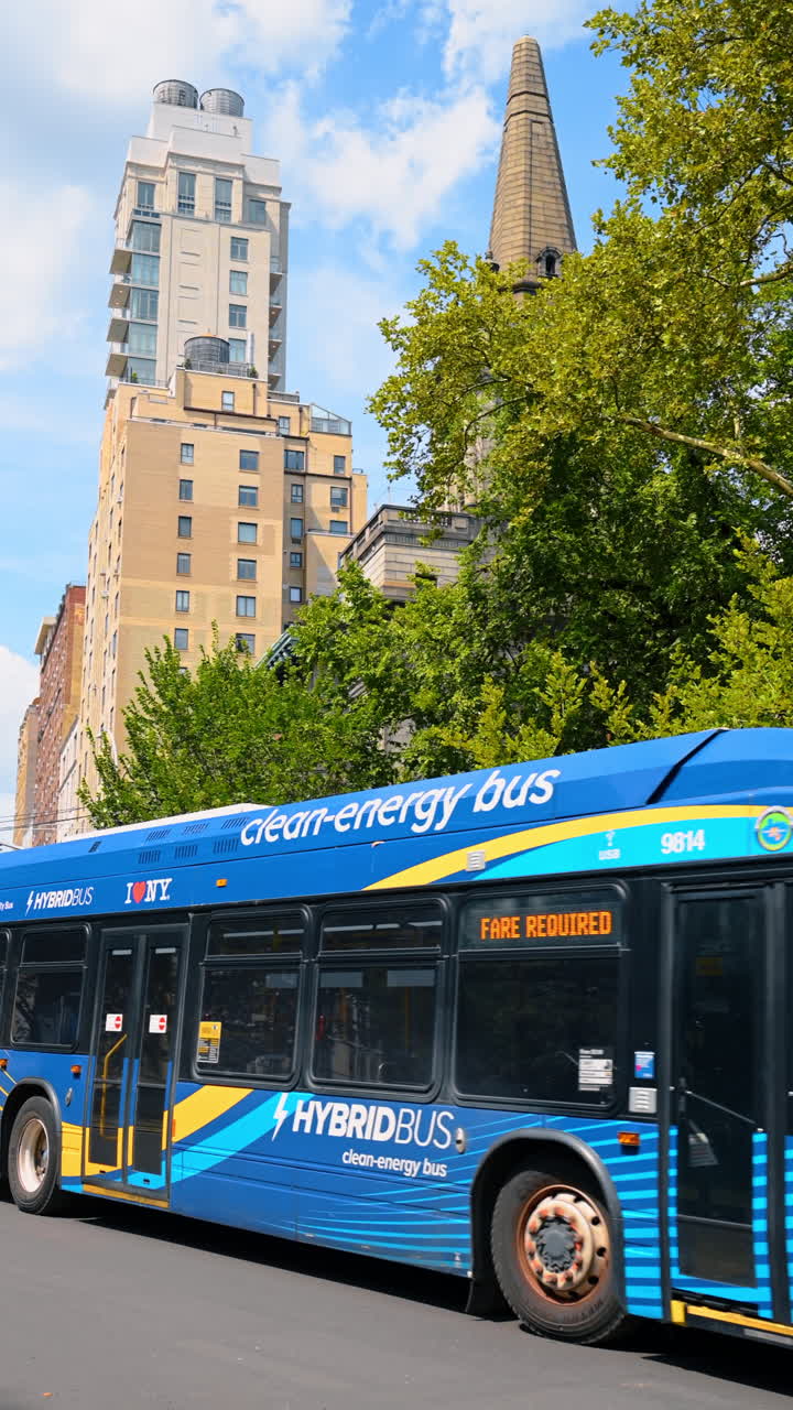 Bus on Central Park West. A city bus moves along Central Park West with tall buildings above