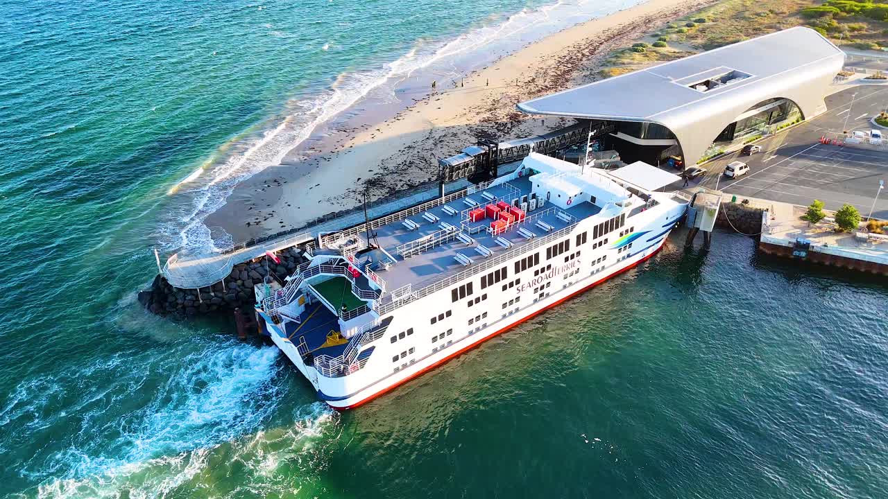 Aerial view of a ferry docking at Queenscliff Terminal, Bellarine Peninsula, under clear skies with vibrant ocean hues