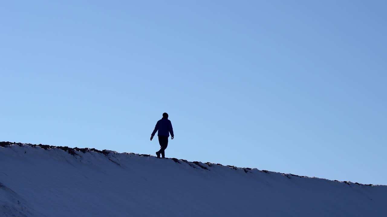 화창한 날에 모래 언덕을 하이킹하는 남자