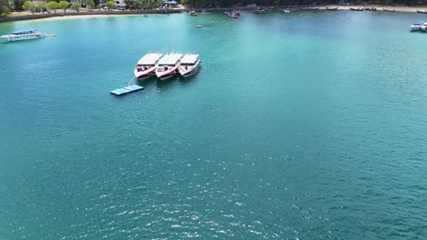 drone footage captures boats on turquoise waters near a tropical beach in phuket, thailand, under bright daylight