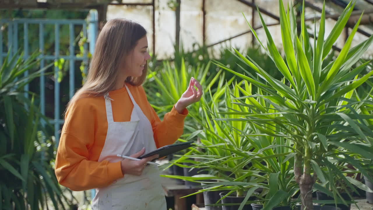 mujer inspeccionando plantas en un invernadero