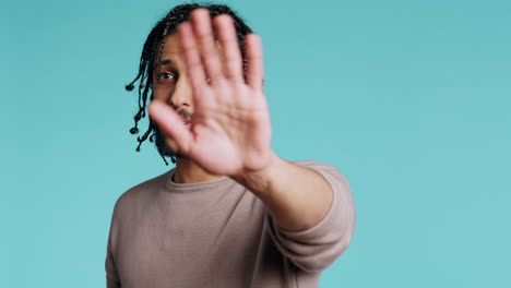 annoyed person doing firm stop sign gesturing, studio background