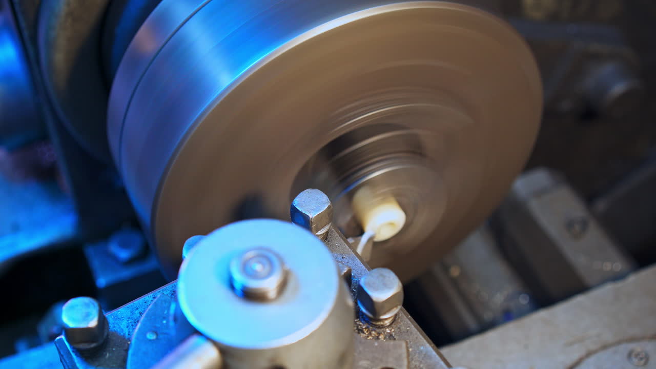 Little plastic detail being grinded out in the lathe. White flakes flying away from the lathe. Close up.