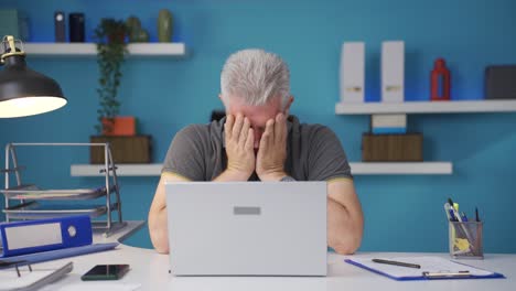 Home-office-worker-man-yawns-and-relaxes-at-the-camera.