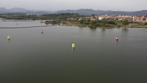 Vuelo-De-Drones-Sobre-El-Agua-Y-Las-Boyas-Listas-Para-La-Copa-Del-Mundo-De-Motos-Acuáticas-En-Olbia-Cerdeña-Mostrando-La-Ciudad-Al-Fondo