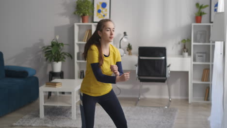 entrenamiento aeróbico en casa niña adolescente está haciendo ejercicios con paso y mover las manos estilo de vida saludable y acondicionamiento físico en el hogar para una buena condición física