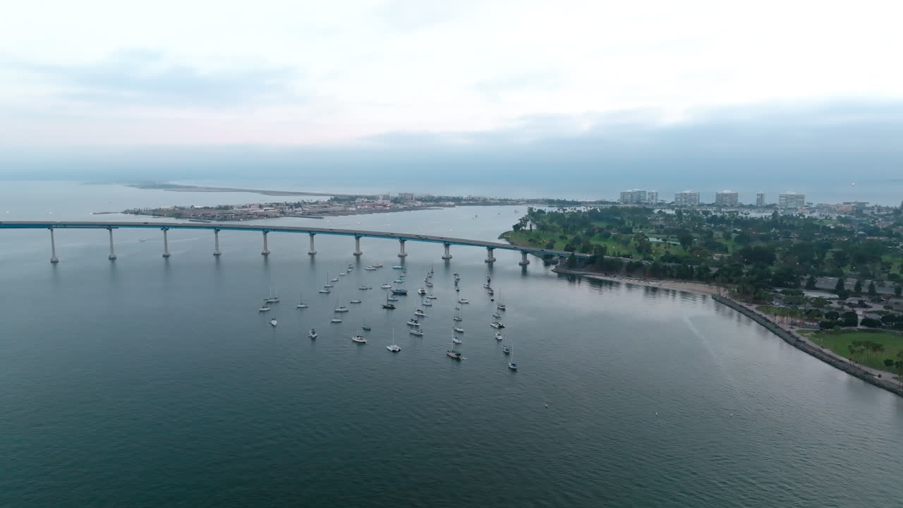 toma panorámica aérea sobre la bahía de san diego, puerto deportivo de la isla coronado cerca del hermoso puente curvo en el fondo