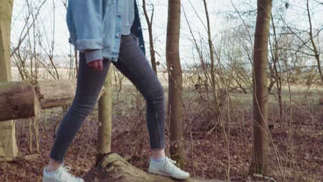 girl balancing on a fallen tree in a forrest