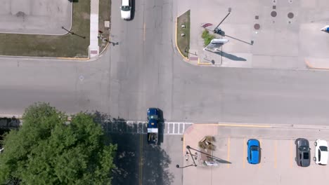 Intersection-in-downtown-Geneseo,-Illinois-with-cars-driving-and-overhead-drone-video-looking-down-stable