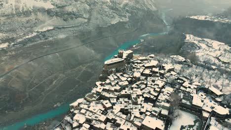 orbital aerial footage of a village hanging off a cliff in karimabad hunza in northern pakistan