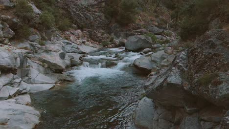 drone fly through of a hidden stony waterfall at dusk