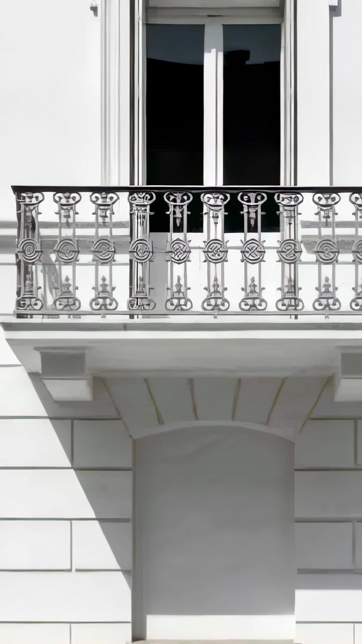 Video verticale: Telecamera che si allontana mostrando il balcone di una facciata, inquadrando una ringhiera decorata e una finestra scura.