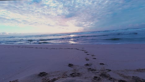 rotating colourful timelapse of sunrise on beach, waves coming in, clouds going out