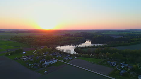 A-Smooth-Shot-Of-A-Small-Sunset-Neighborhood-Landscape-With-A-Lake-And-A-Forest