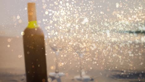 animation of gold dots over blurred bottle of red wine on beach