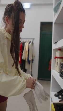 woman trying on white gloves in a clothing store