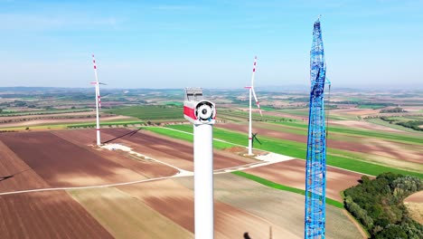 torre de turbina eólica erigida con góndola junto a la grúa de construcción en un parque eólico