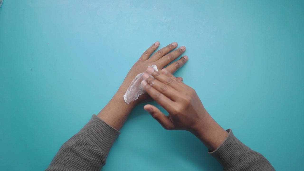 Top View of Person Applying Moisturizing Cream to Hands