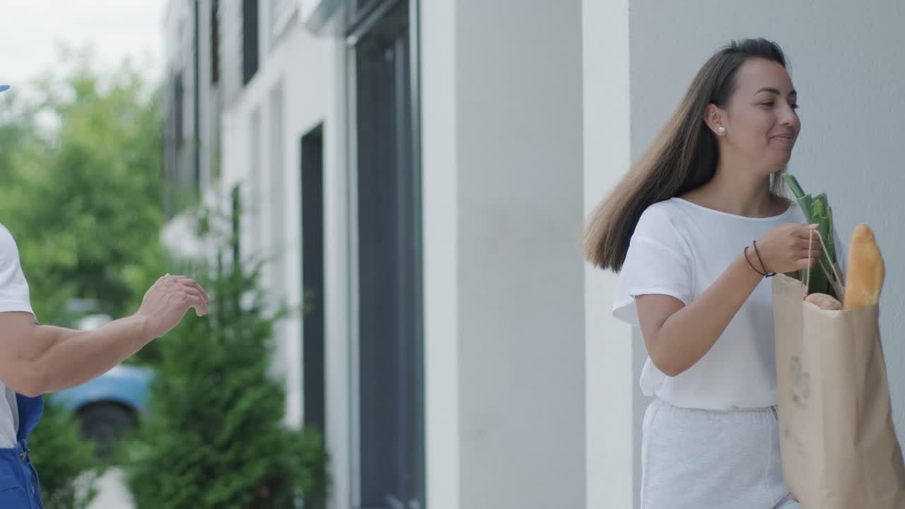 아름다운 여자가 그녀의 집 에 음식과 함께 쇼핑 패키지를 주는 배달 남자를 만난다. 음식 배달, 택배, 집 배달, 온라인 쇼핑의 개념