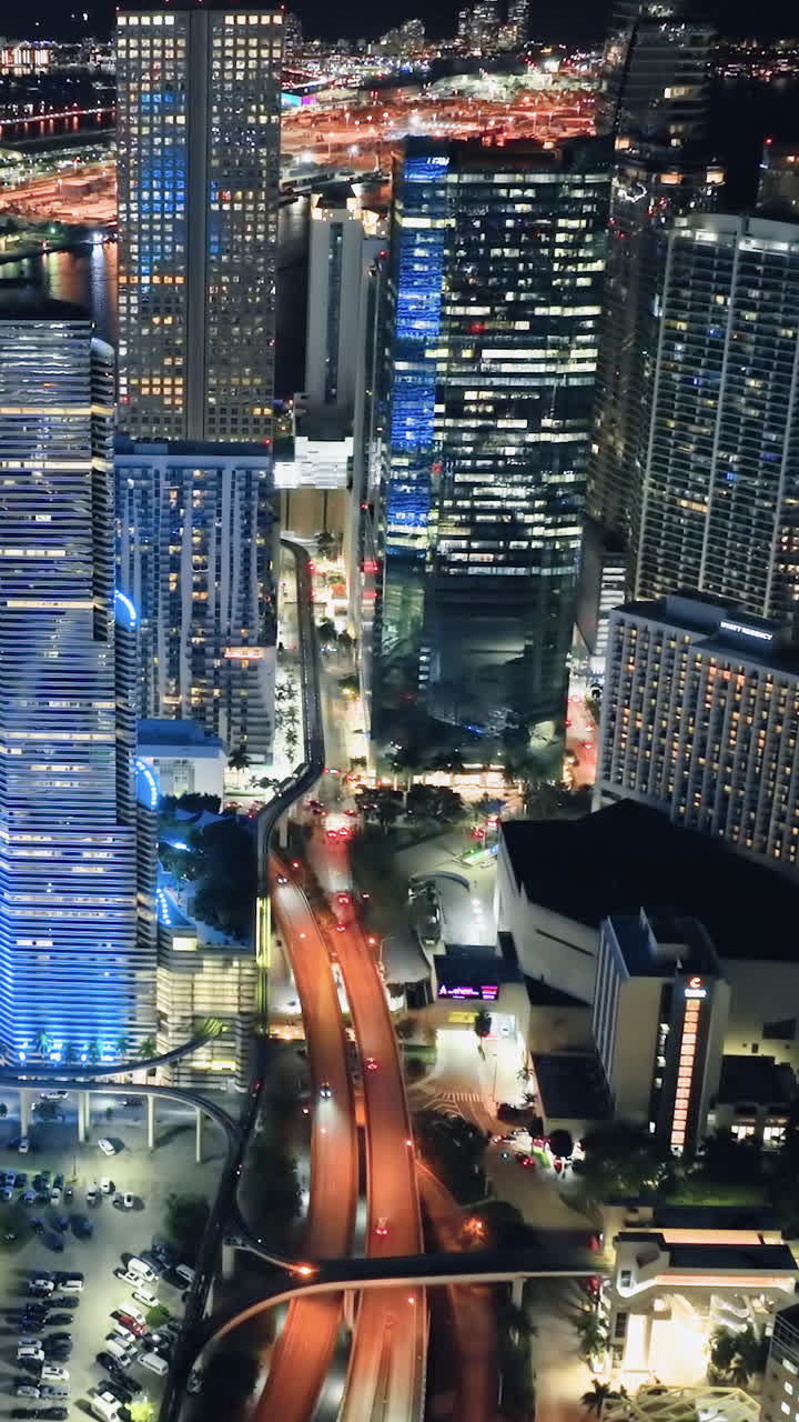 Night lights in downtown Miami. Glowing skyscrapers and electric street lighting. Vertical video