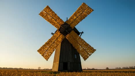 a majestic windmill standing tall against a clear sky, showcasing its unique yellow blades and surrounding fields at dusk, emphasizing the beauty of rural landscapes