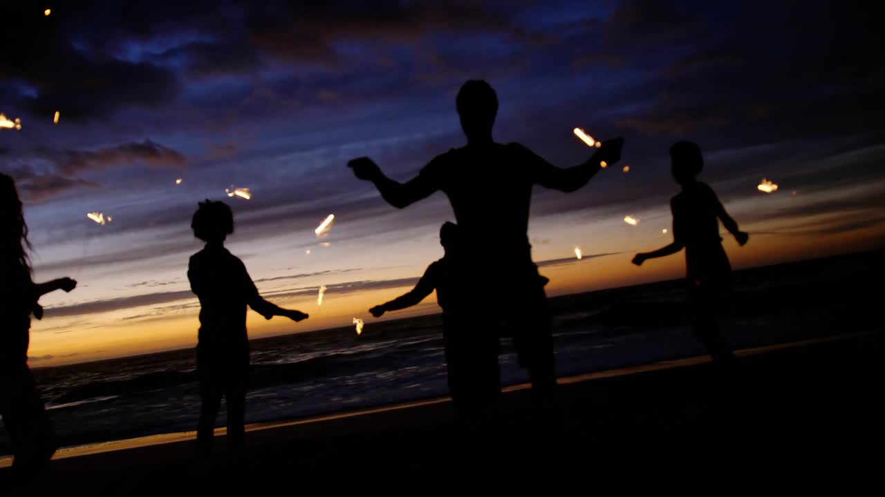 해변에서 반 ⁇ 이는 불꽃으로 놀고 있는 친구들 4k