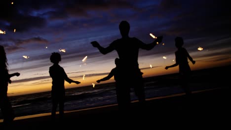 friends playing with sparklers on the beach 4k