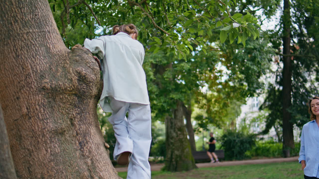 Mom kid walking park. Little girl jumping on tree enjoying time with parent