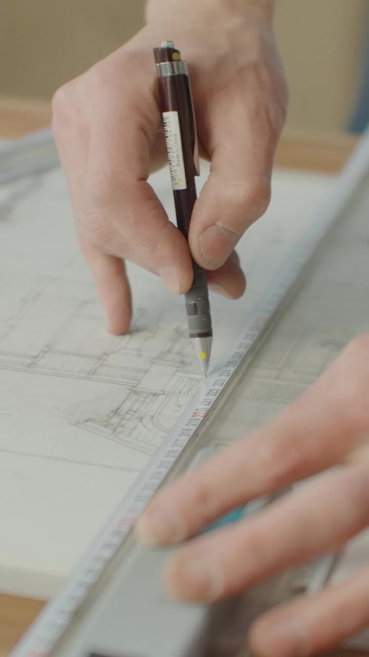 Arquiteto usando régua e lápis para medir desenho técnico