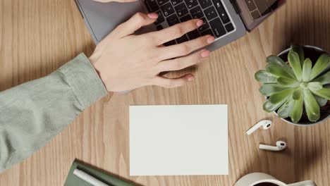 persona que escribe en una computadora portátil en la oficina de su hogar