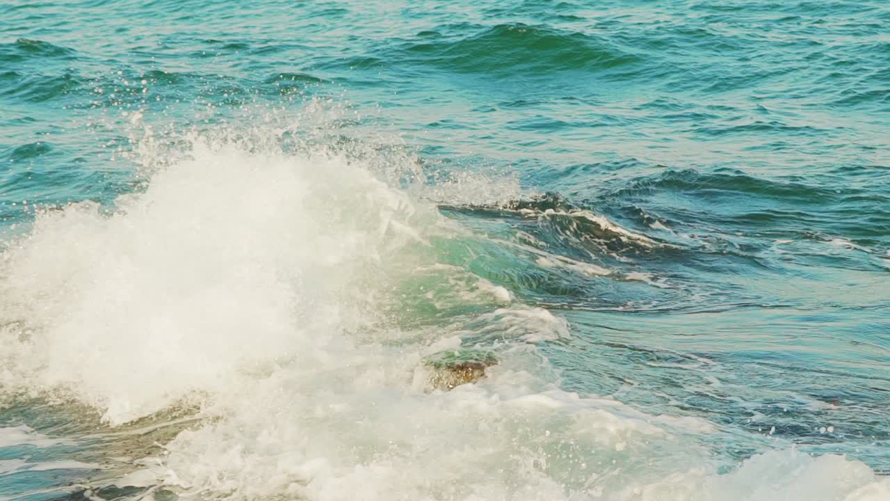 Breakwater and splashes of wave in sea shore. Slow motion