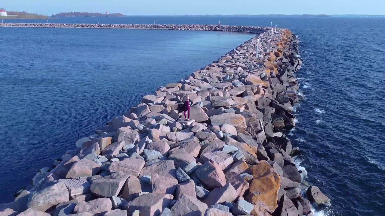 молодые женщины, стоящие на скалах у береговой линии