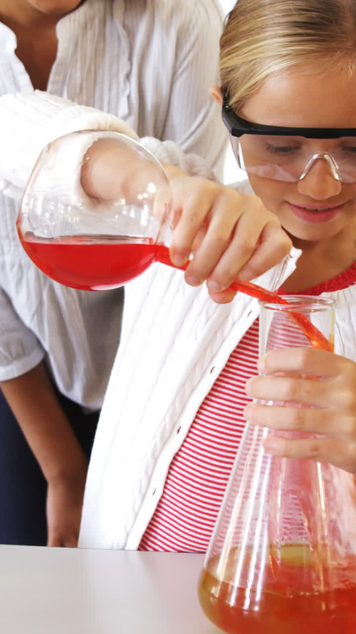 niños de la escuela haciendo un experimento químico en el laboratorio