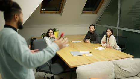 team of entrepreneurs sitting at the conference table, listening to the speaker, slow motion