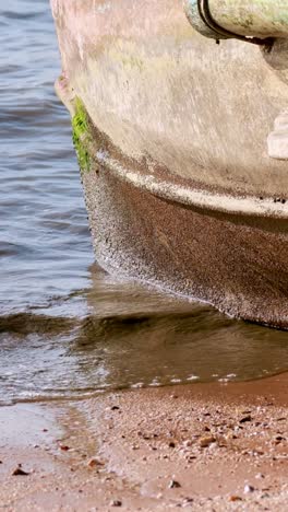 las olas golpean suavemente contra un barco varado