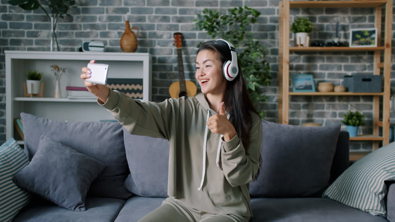 Woman Taking Selfie on Couch with Headphones