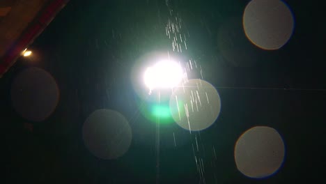 footage of rain falling in the front of a street light