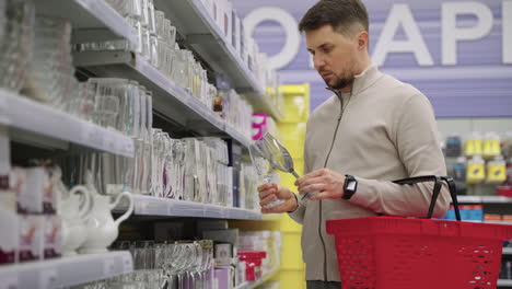 hombre comprando artículos de vidrio en un supermercado