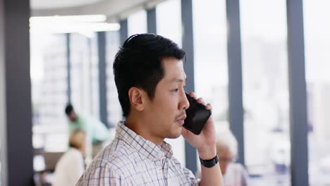 talking on smartphone, man in office setting focusing on conversation