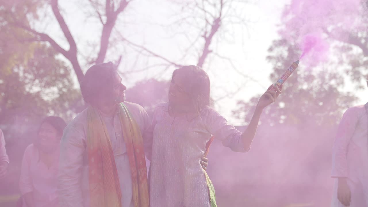 Coppia indiana romantica con una candela a polvere fumogena a una festa Holi.