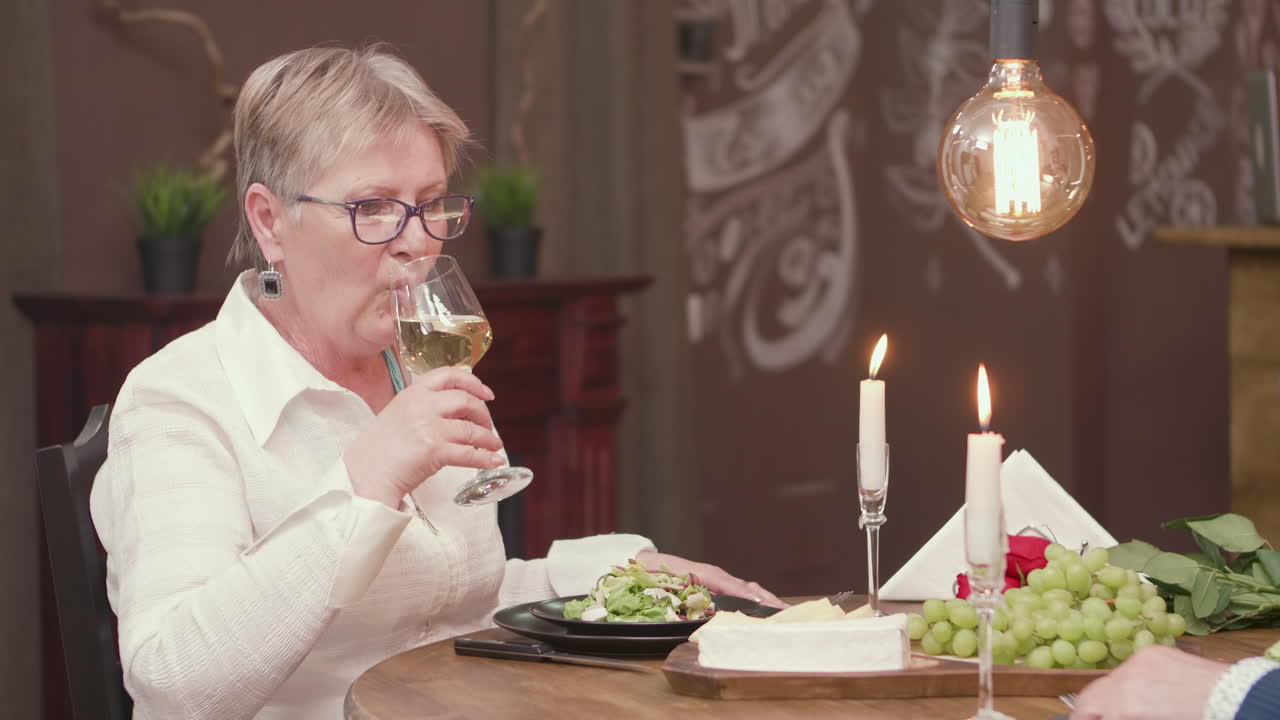 Woman Enjoying a Glass of Wine During Dinner