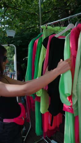 mujer comprando ropa de colores al aire libre