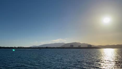 Birdview-of-the-Tejo-river-with-big-sun-and-Troia-cityscape