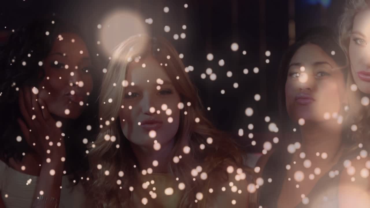 ⁇  빛나는 반점이 배경에서 파티를 하는 여성들의 그룹에 대해 움직입니다.