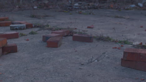 tilt-down-shot-of-abandoned-industrial-area-to-a-pile-of-bricks-that-remain-from-the-destruction