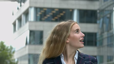 Beautiful-business-woman-looks-around-office-buildings-with-fascination